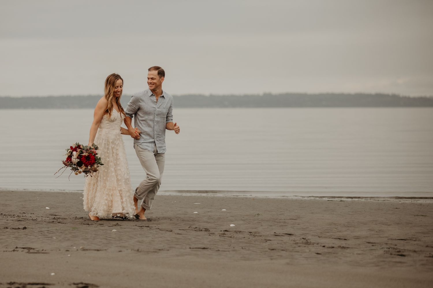 Bride and Groom run along Whidbey Island beach