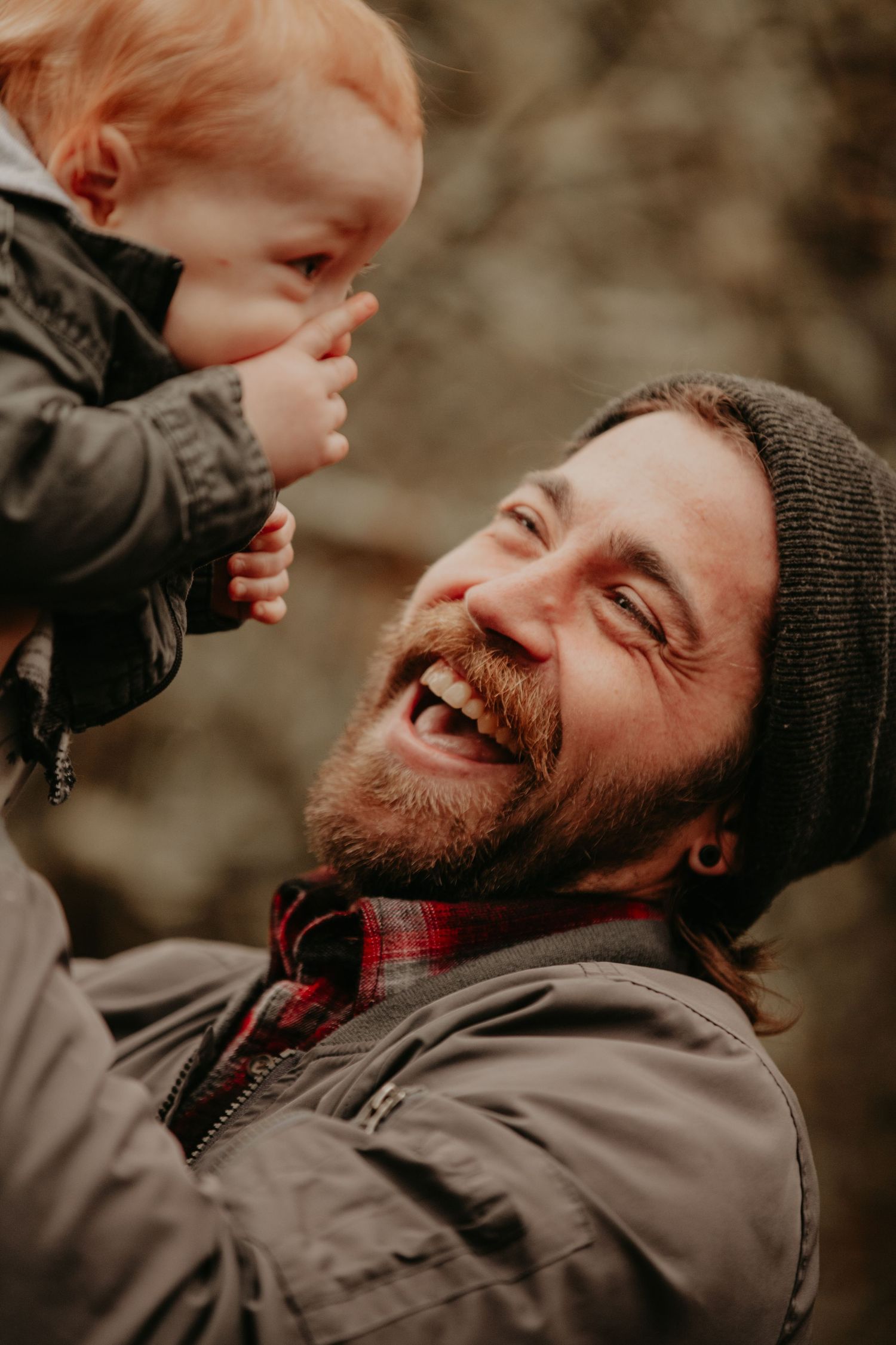 A joyful moment captured between parent and child sharing laughter during an outdoor autumn day.