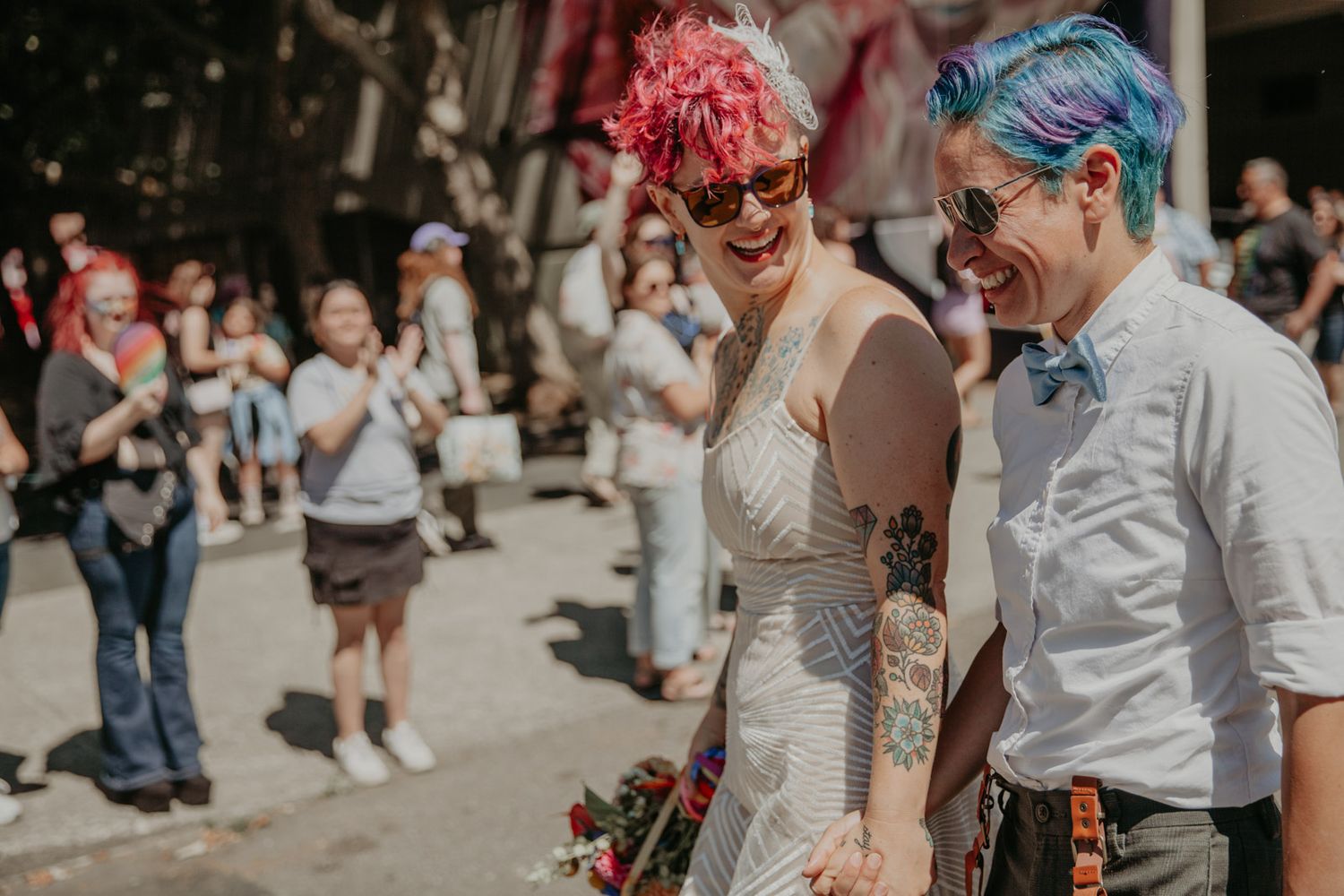 Wedding guests dance and celebrate during an outdoor reception with colorful decor and festive atmosphere.