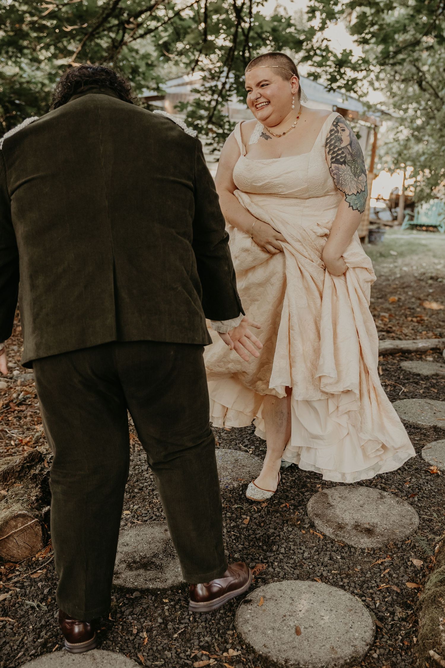 Wedding couple's feet and dress details on woodland ground showing playful interaction.