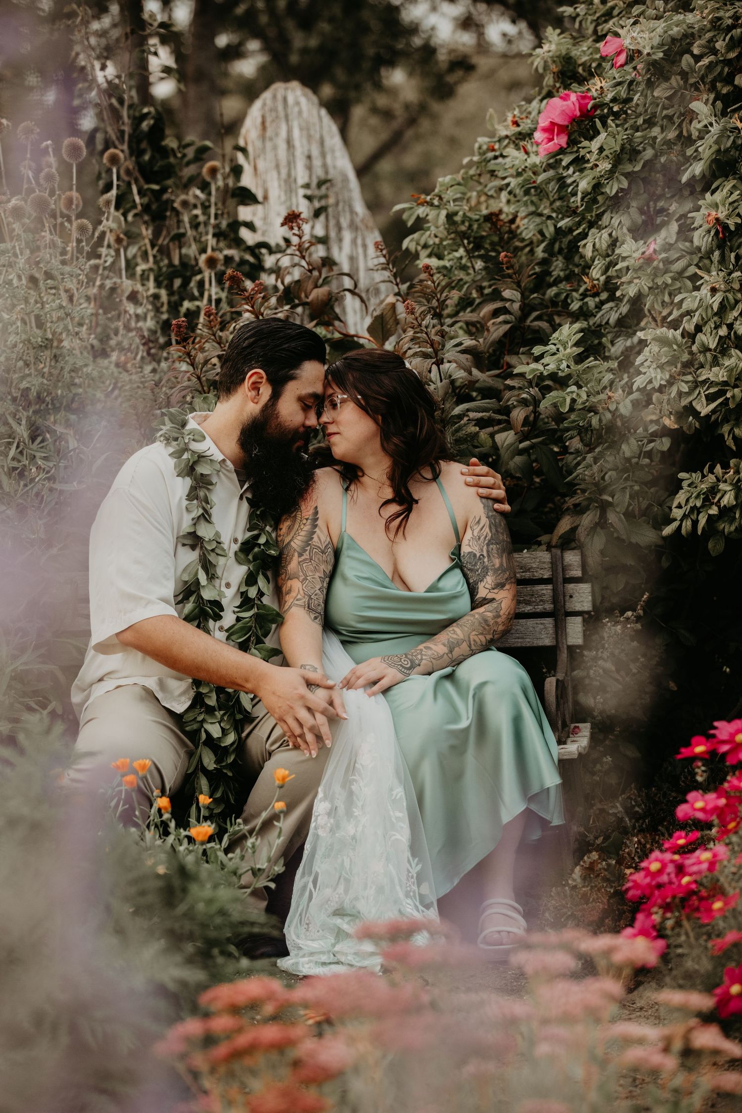 Romantic couple embraces in lush garden setting with blooming roses and dreamy lighting.