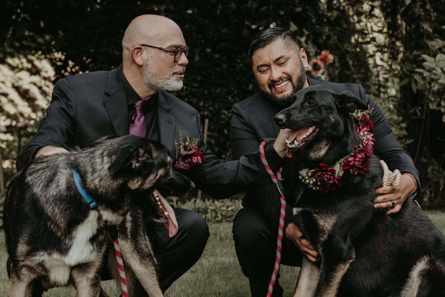 Wedding group poses with playful expressions and black formal attire in an outdoor garden setting.
