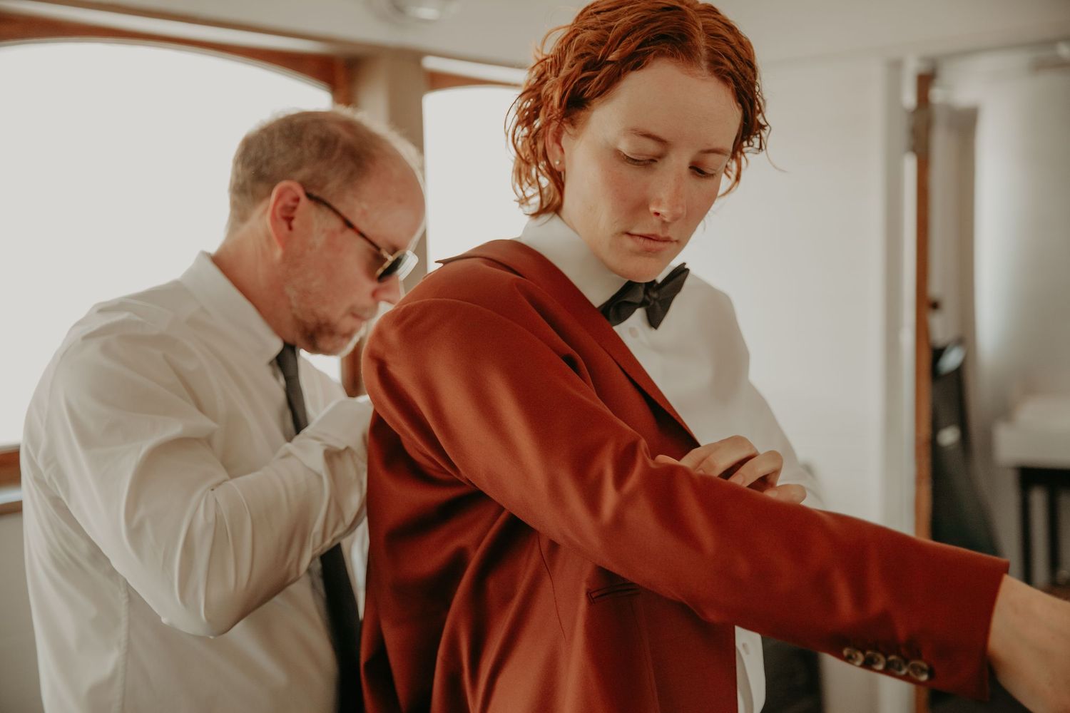 Two people in business attire collaborate and review documents together in a modern office setting.
