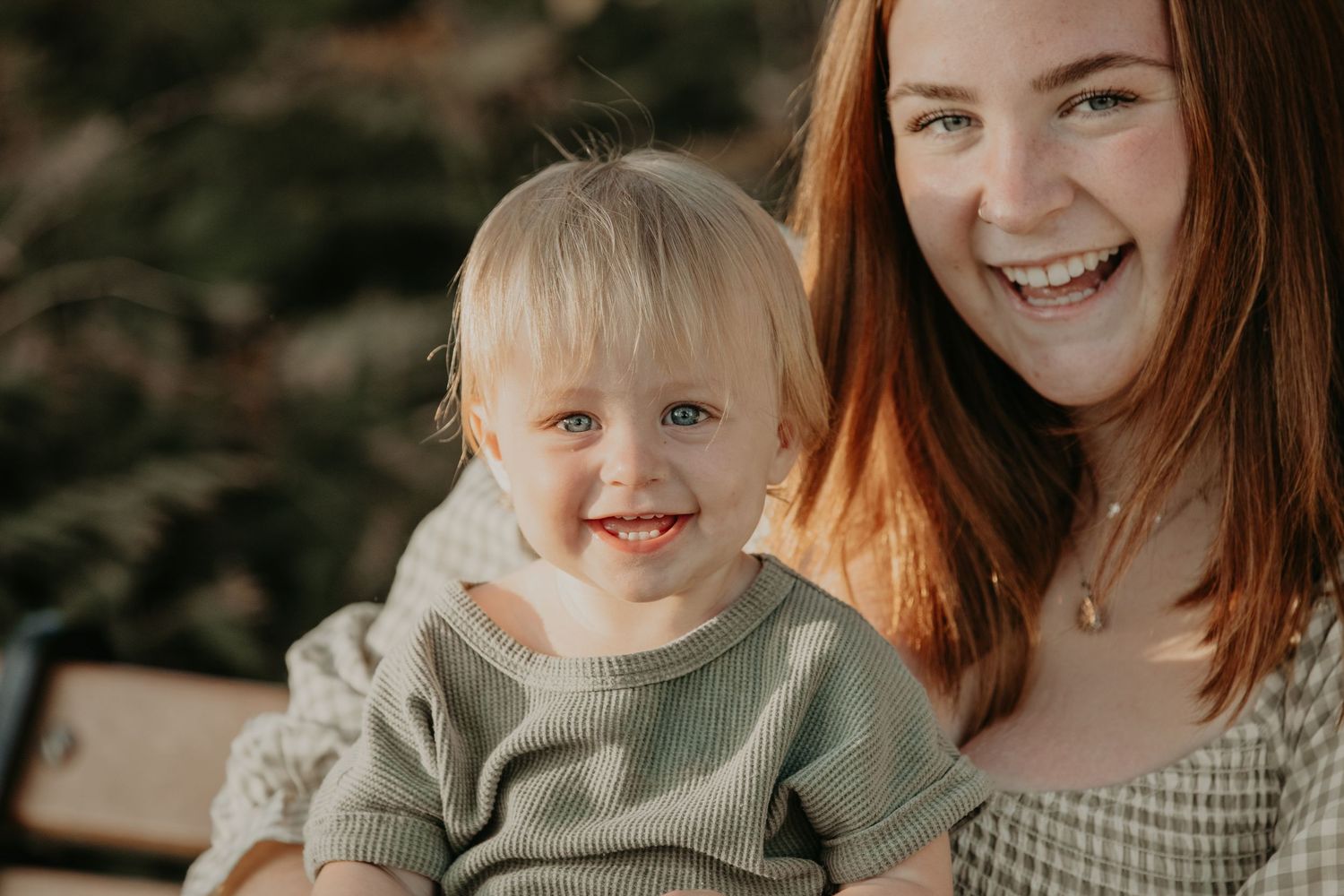 Family portrait showing tender moments with baby in olive green clothing outdoors.