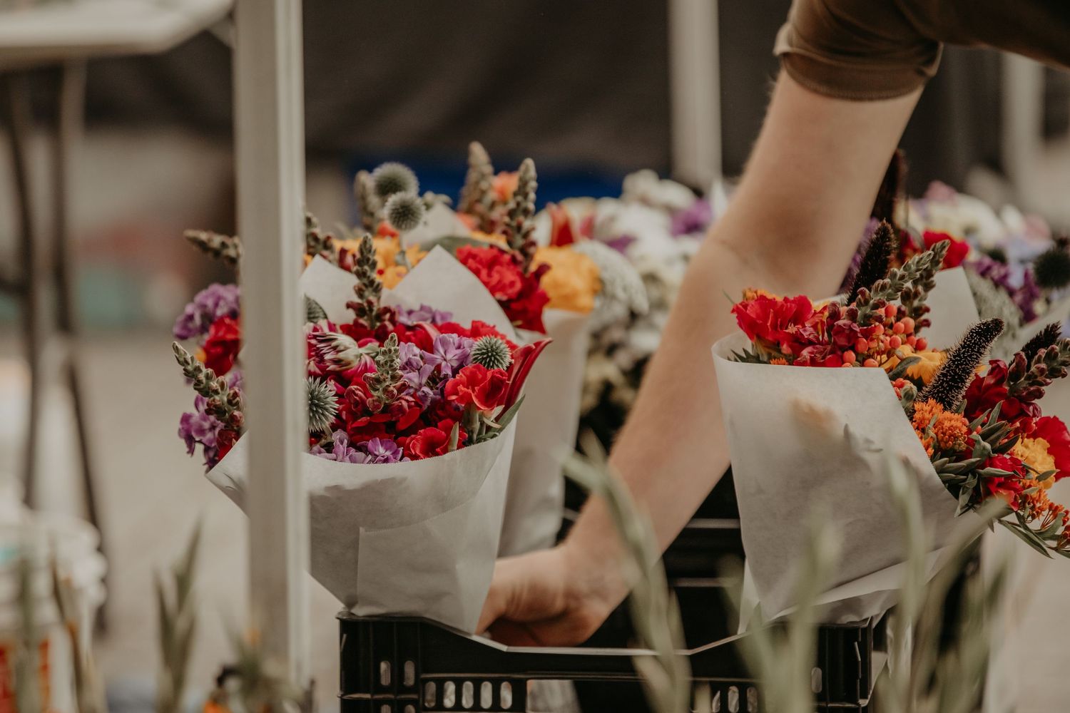 Close-up of various colorful flower bouquets arranged on a wooden table.