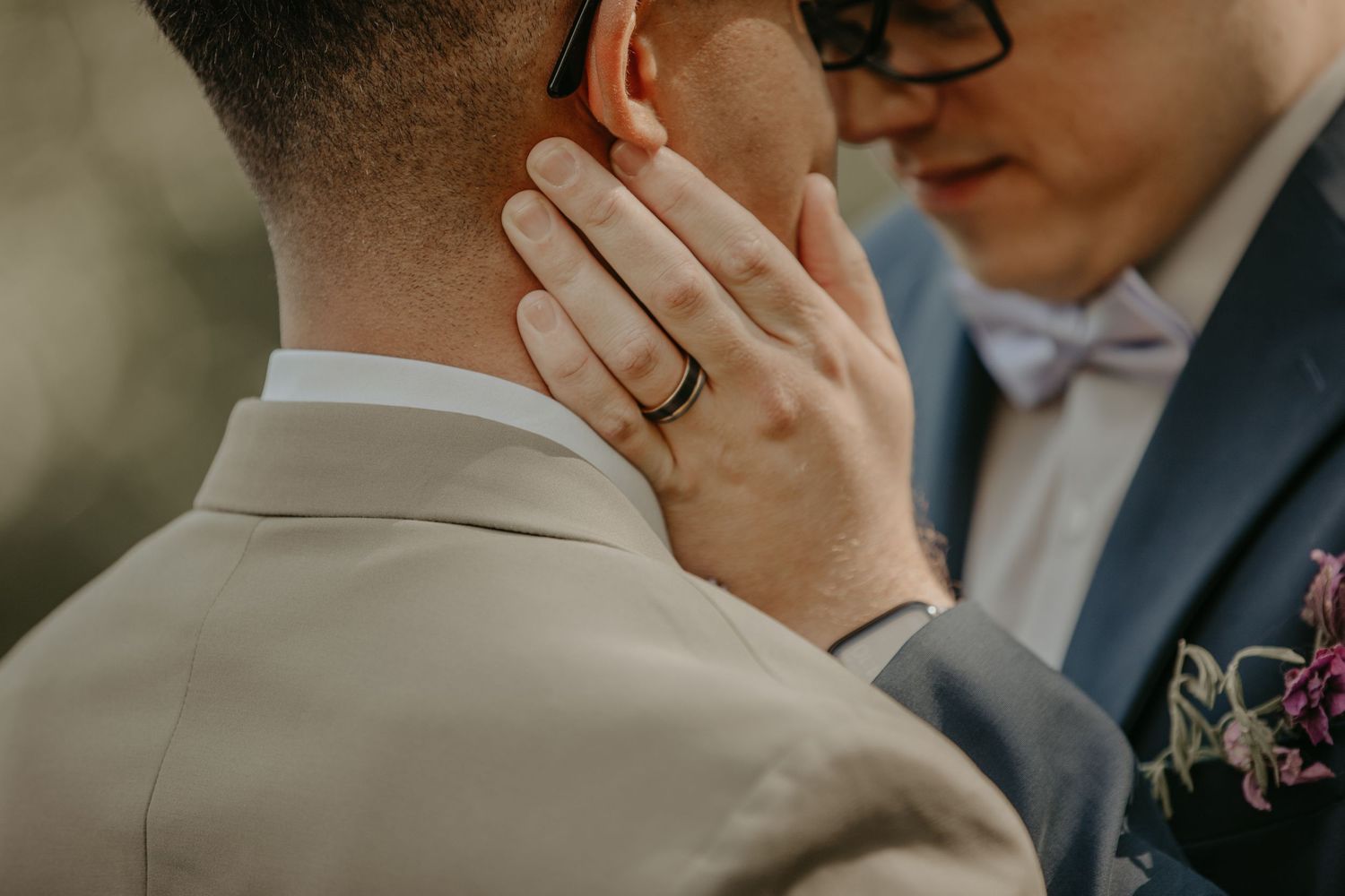 Close-up shot of an intimate romantic moment between two people outdoors with soft bokeh lighting.