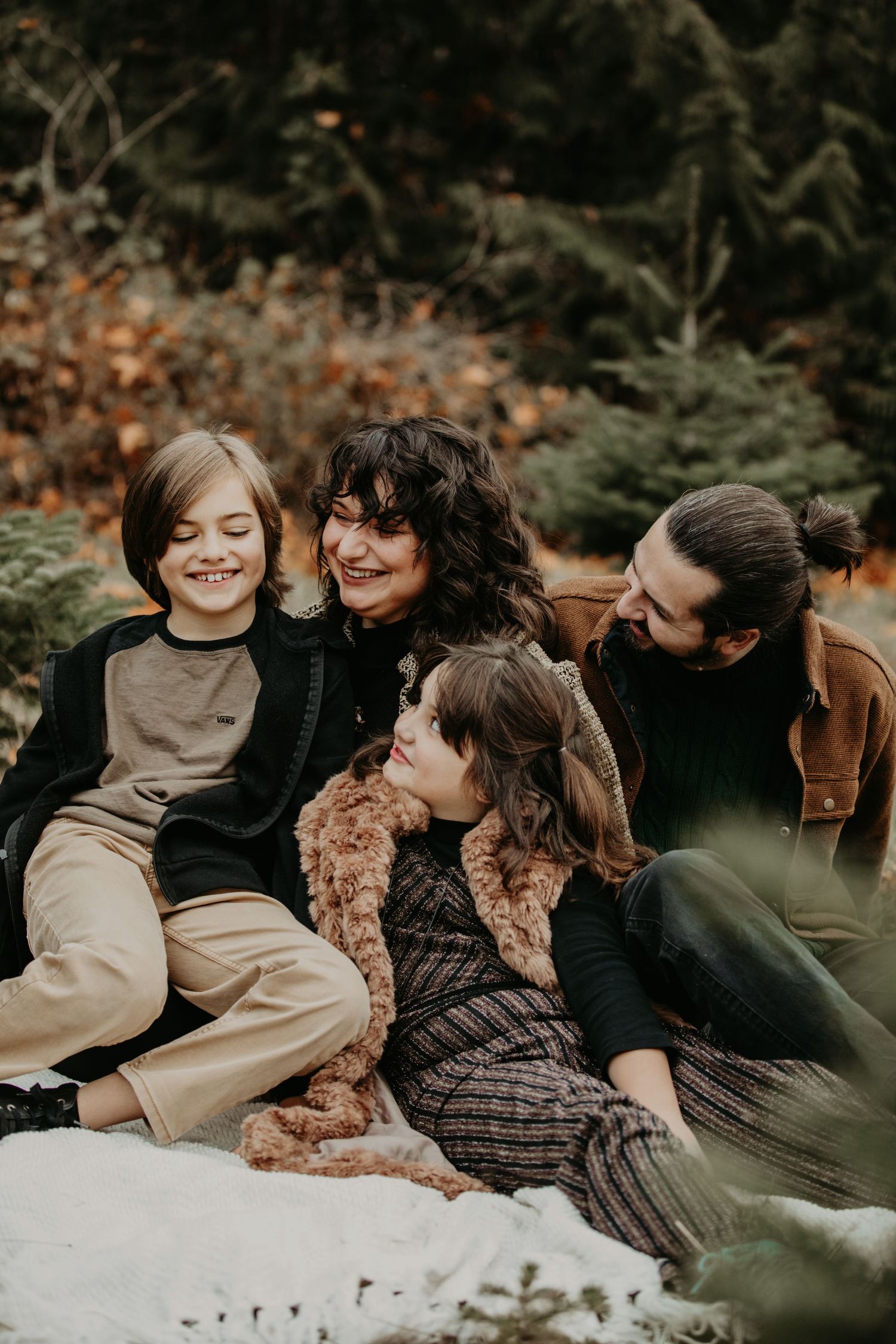 Family laughs together during casual outdoor autumn photo session.