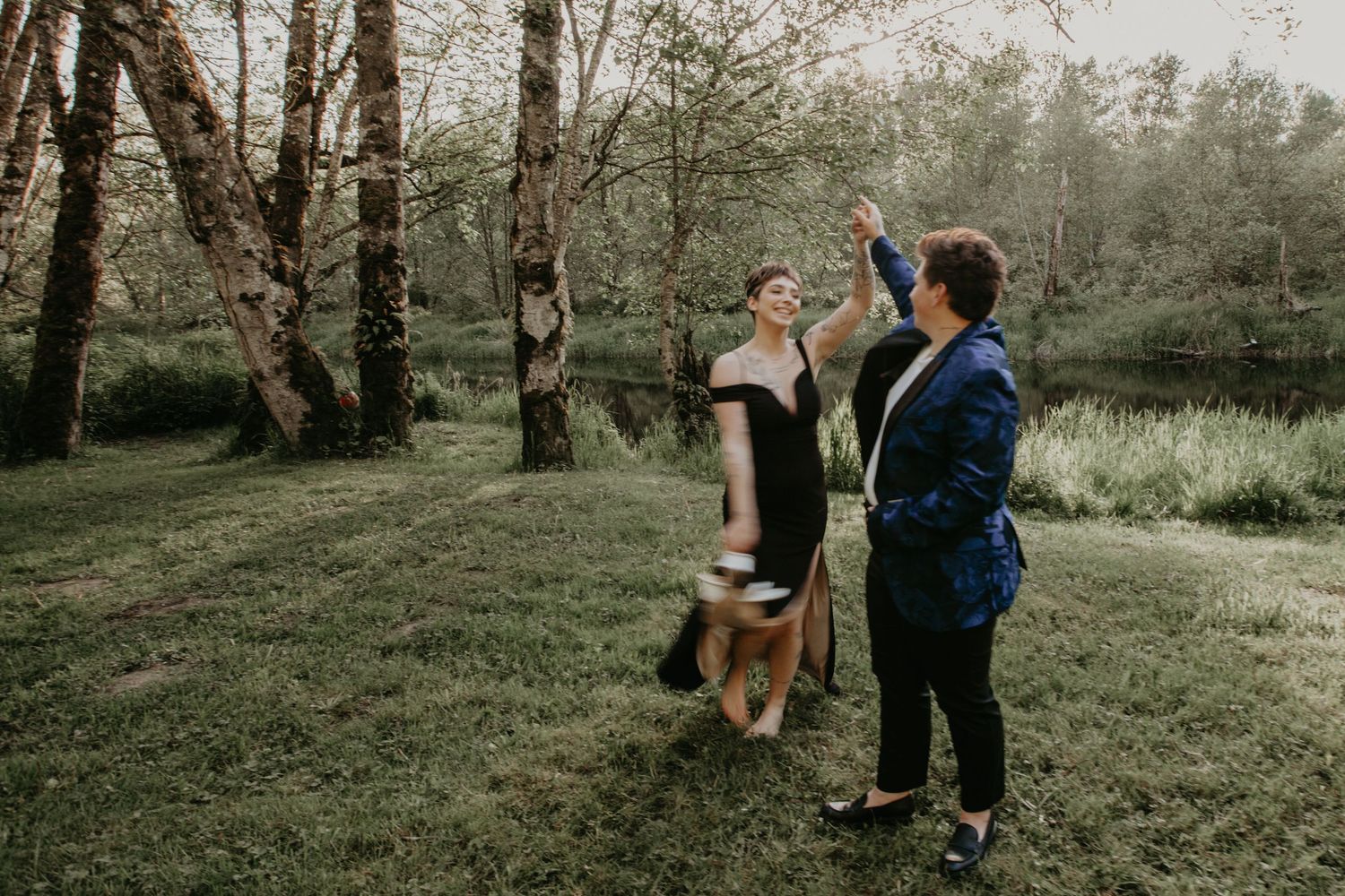 A couple dances together in a dreamy forest setting during a romantic outdoor photo session.