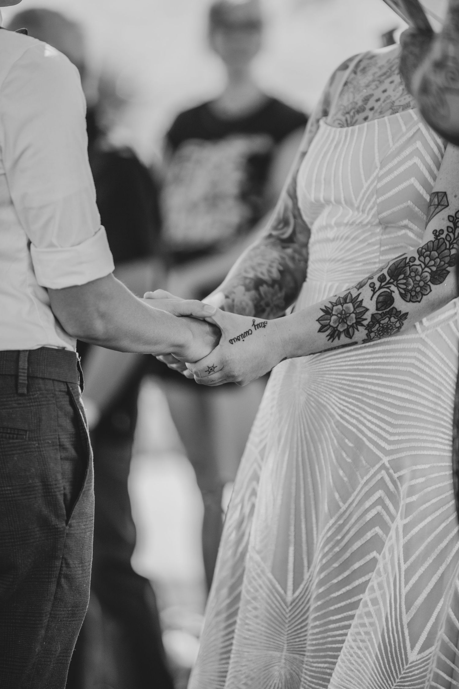 Black and white photo showing hands exchanging rings during a wedding ceremony.