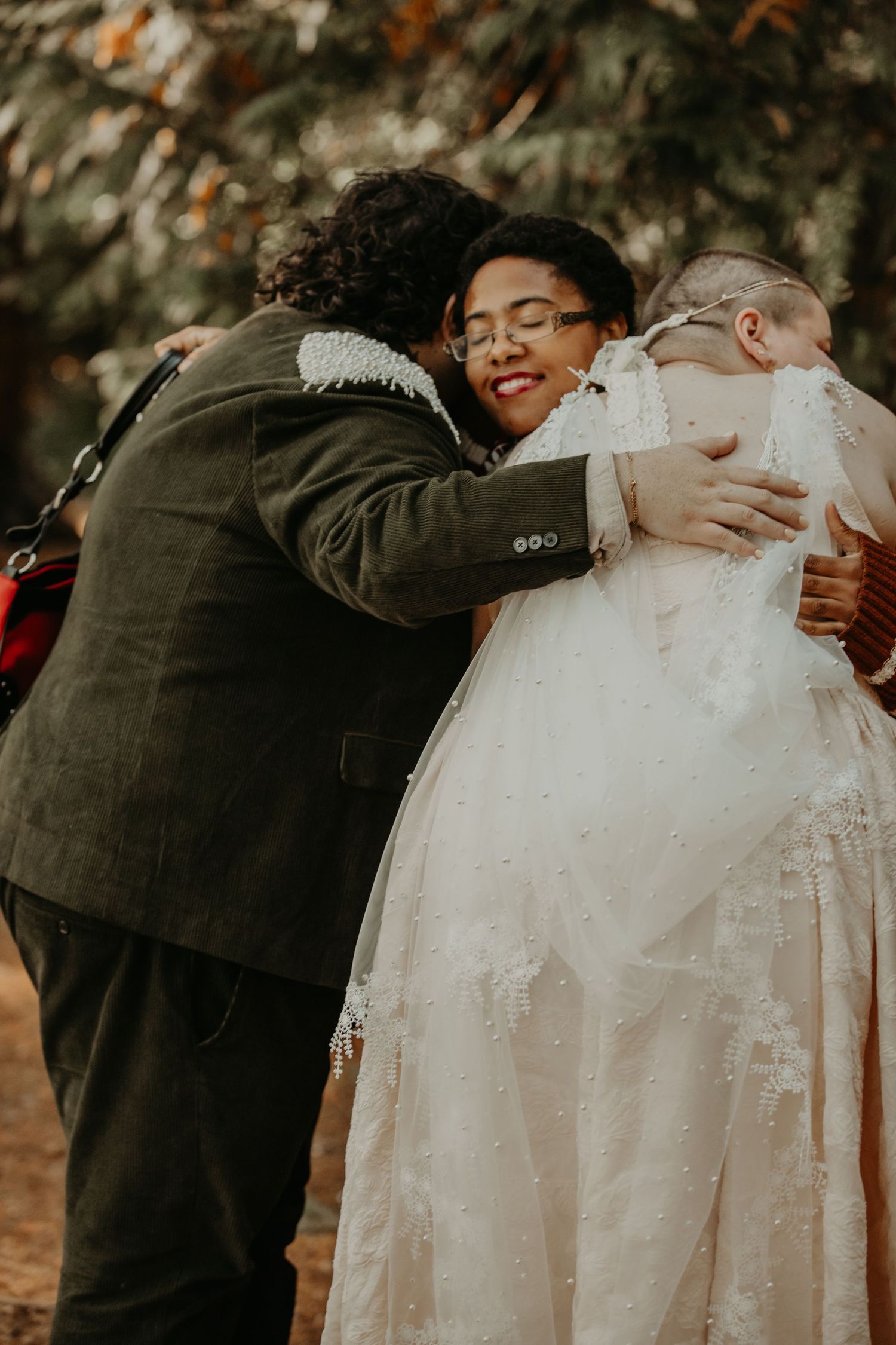 Wedding guests share warm embraces and hugs during an emotional outdoor celebration.