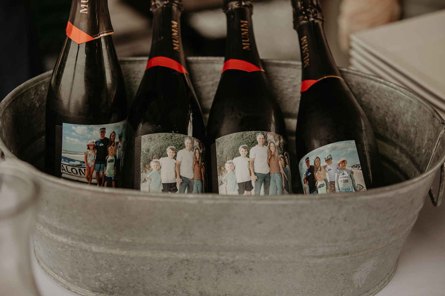 Dark wine bottles chilling in an ice bucket with condensation on their surfaces.