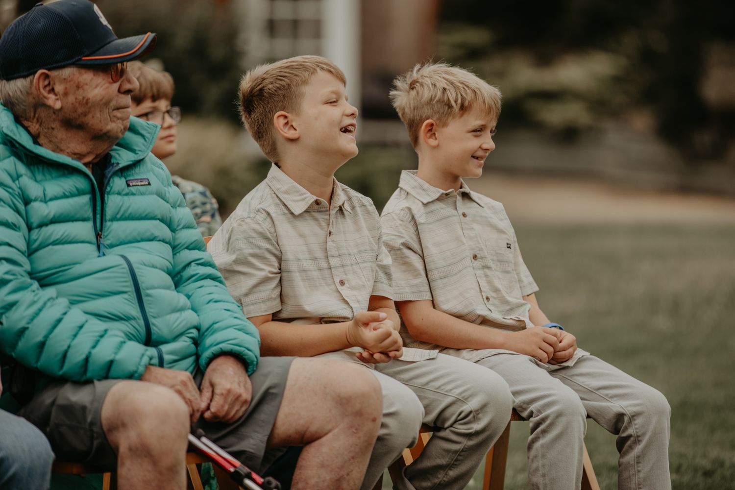 Three children sit together on a bench wearing matching outfits in a candid outdoor setting.