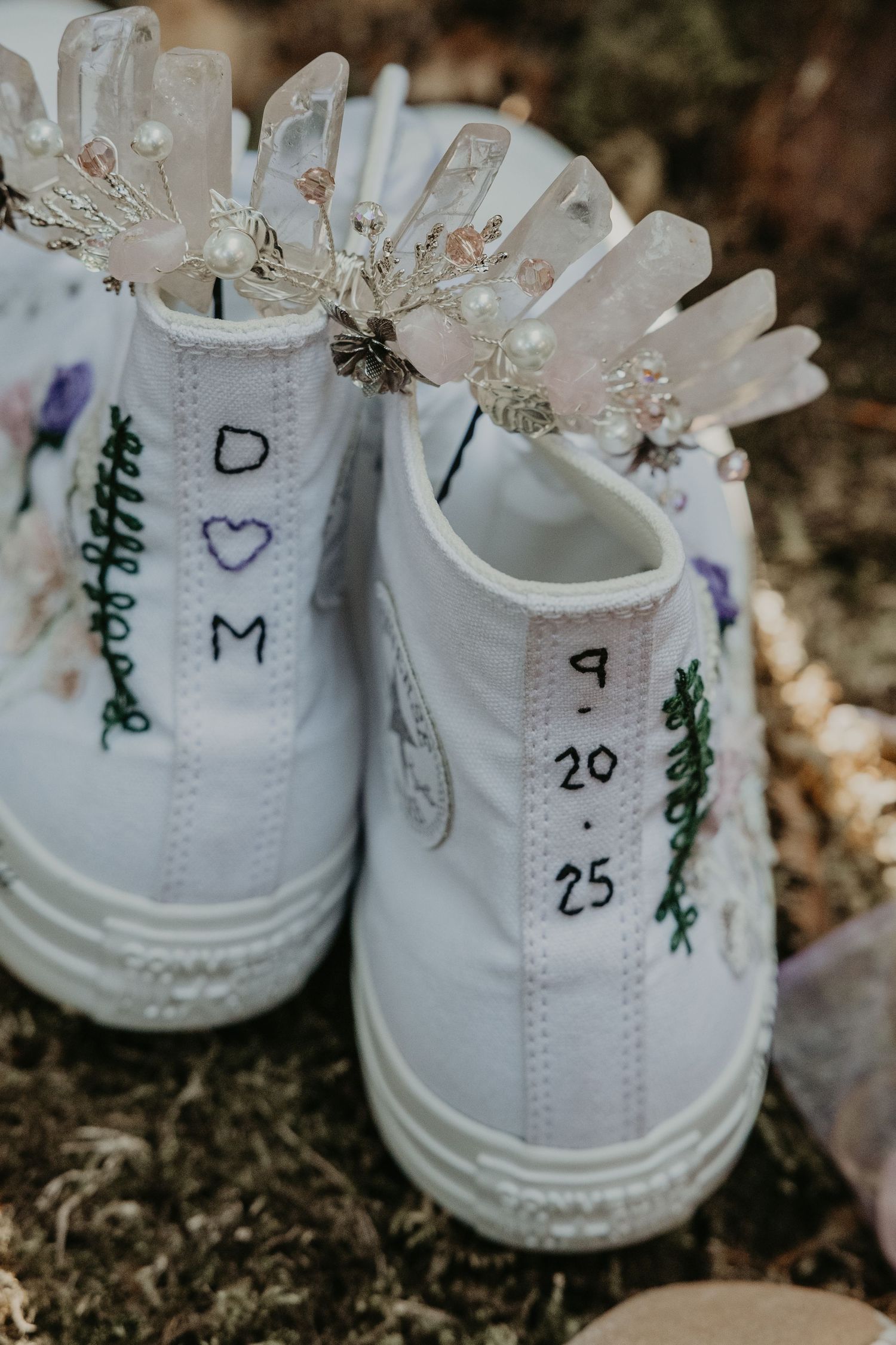 White wedding sneakers with handwritten dates and hearts decorated with delicate floral details.