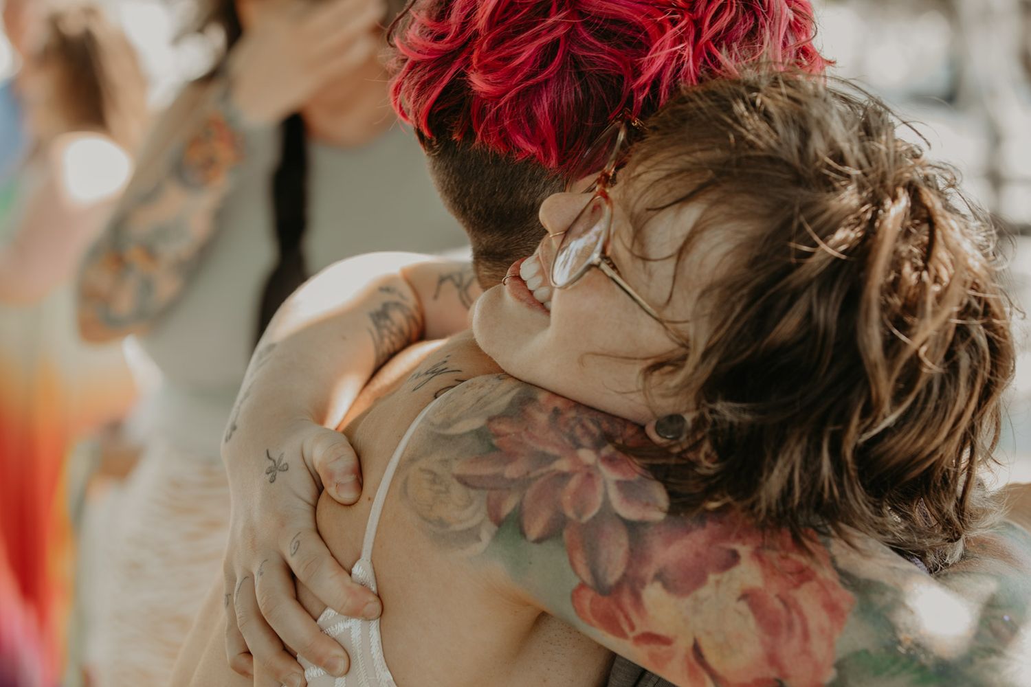 Two people share an intimate moment during a wedding ceremony with soft bokeh lighting in the background.