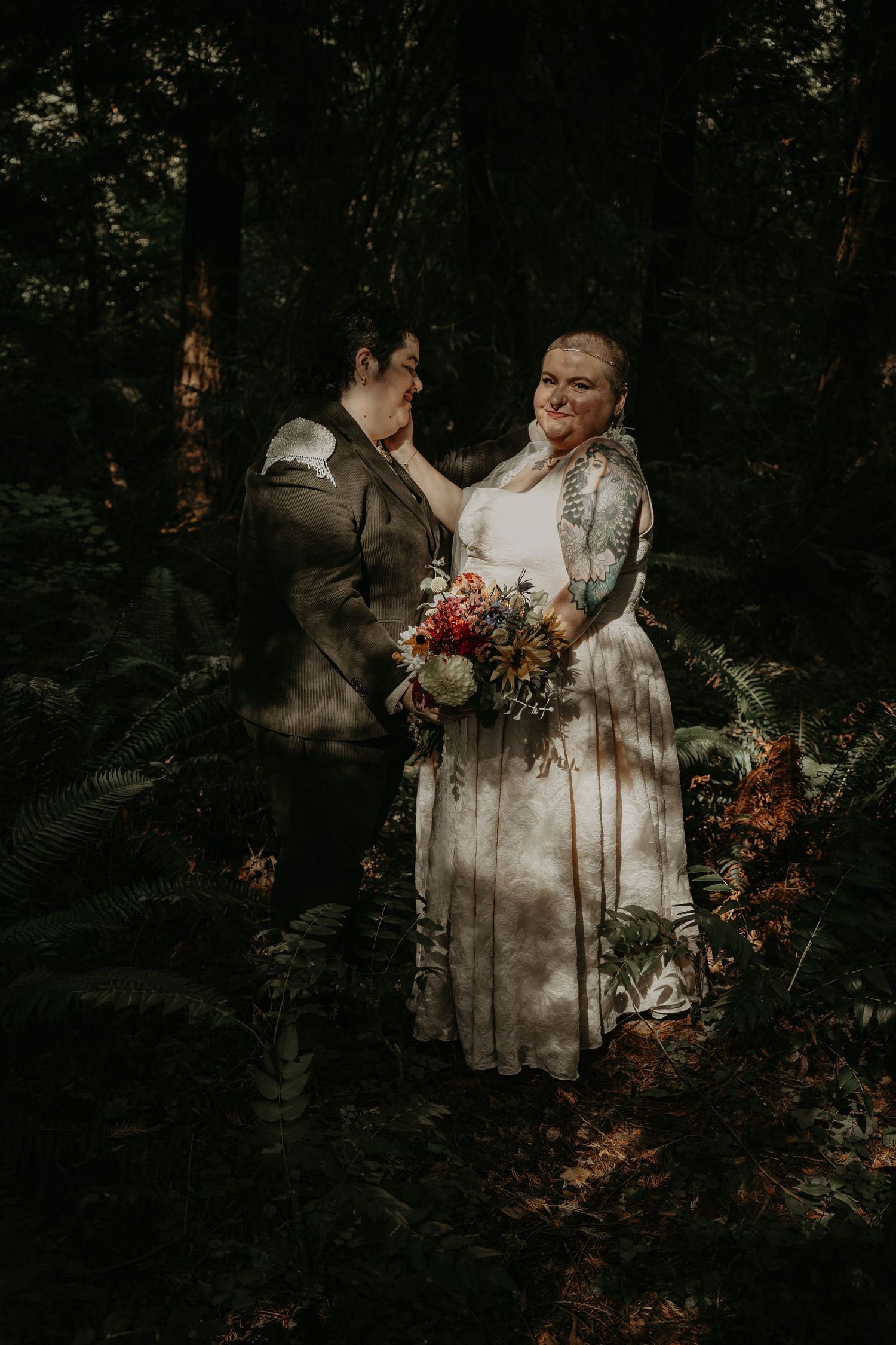 A romantic forest wedding scene with sunlight streaming through trees illuminating a couple in moody, atmospheric lighting.