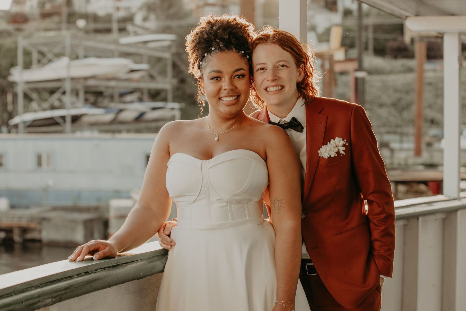 A happy couple shares intimate moments in an urban setting wearing a white gown and burgundy suit.