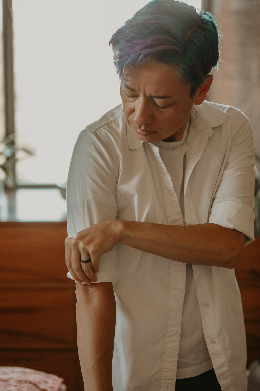 Healthcare worker in white uniform examining patient records at desk in medical facility.