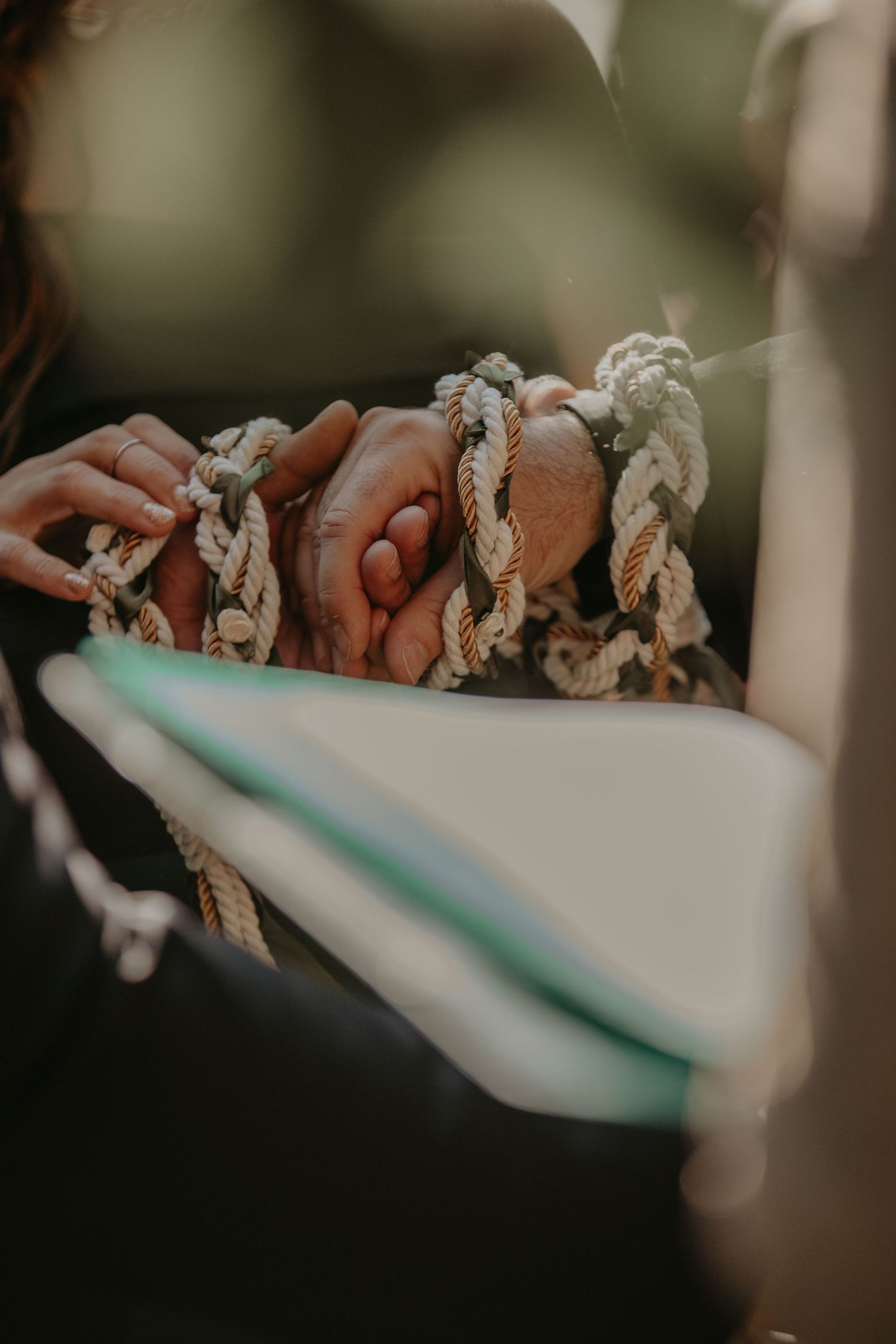 Close-up view of hands holding a twisted rope against a blurred background.