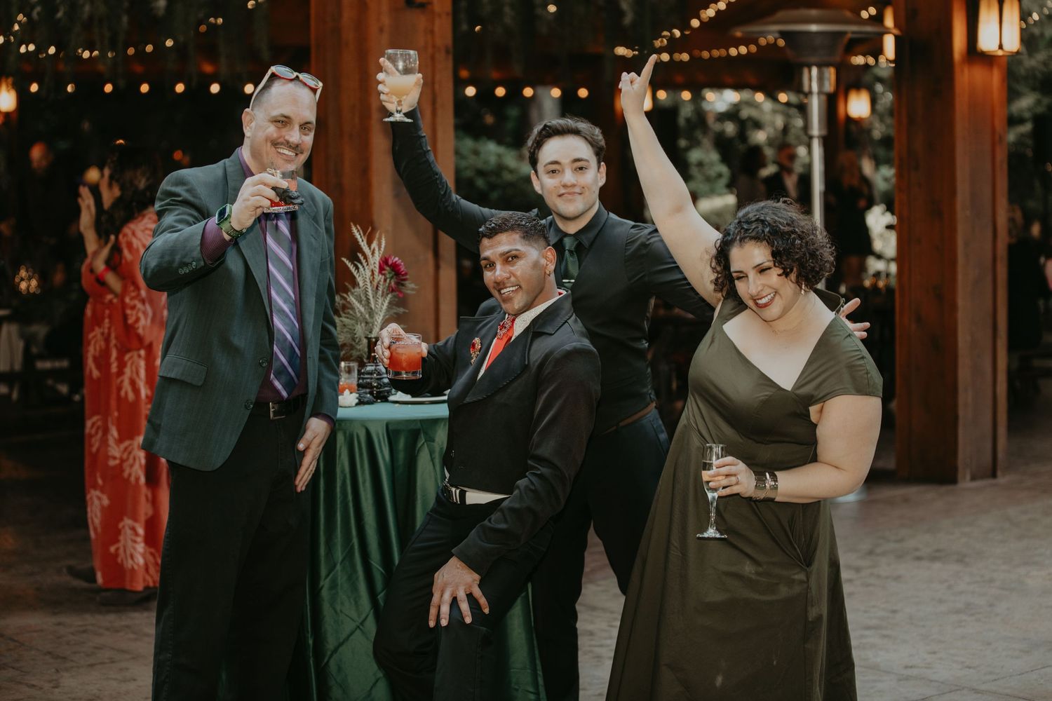 A dimly lit indoor celebration with string lights and guests mingling at a reception.