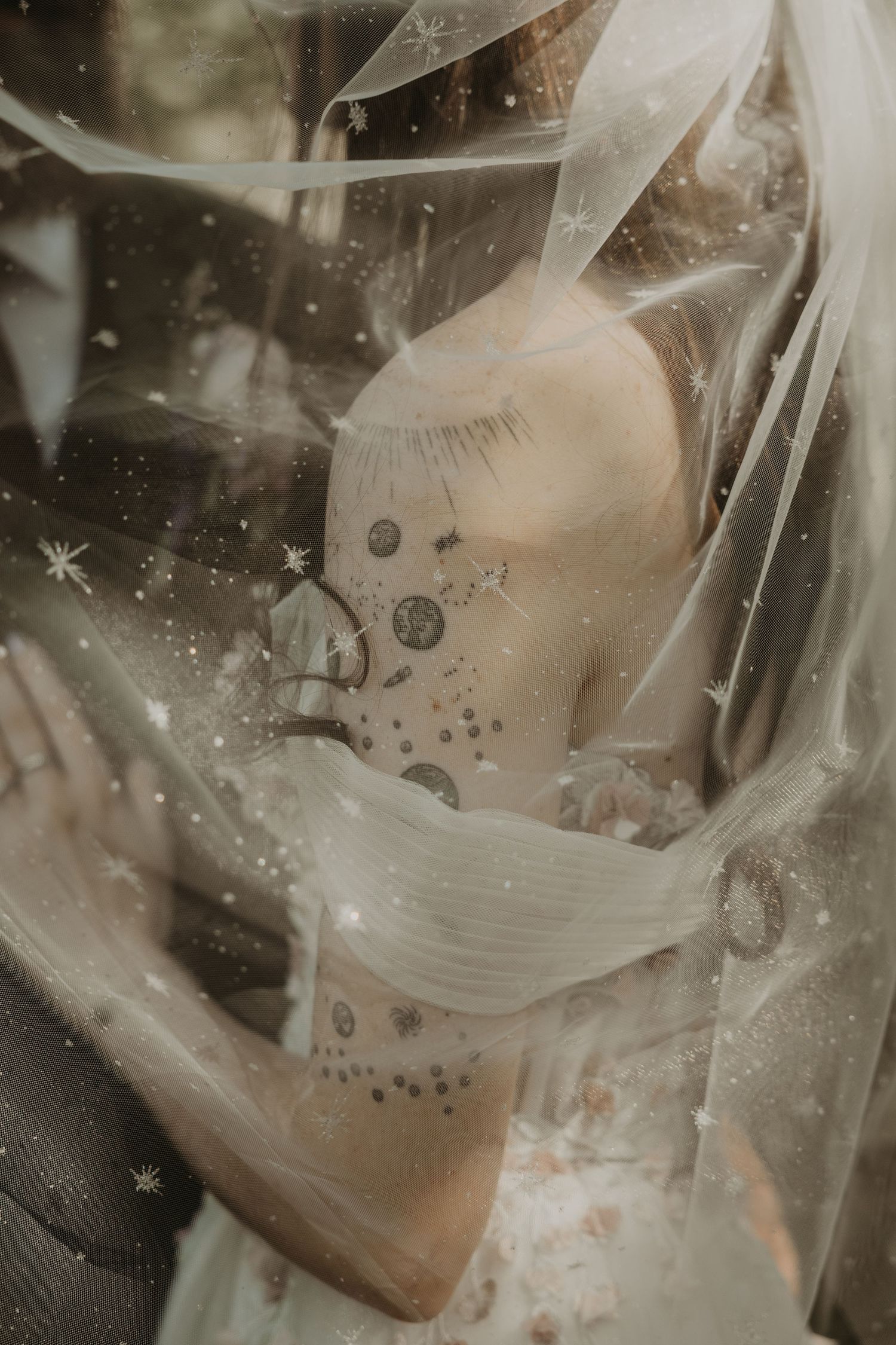 Ethereal and dreamy artistic photography with soft white fabric and sparkling elements creating a mystical atmosphere.
