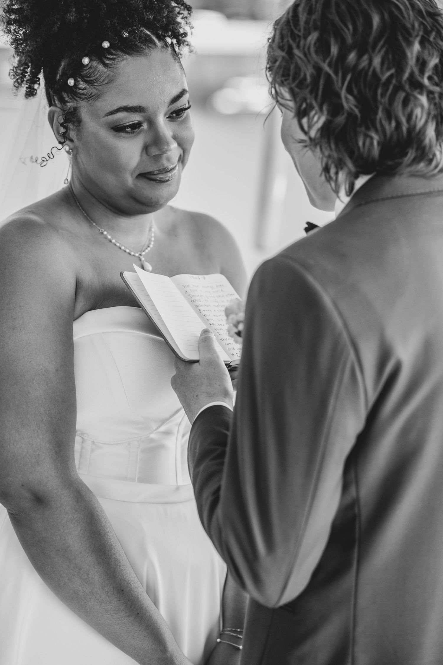 Black and white series showing an intimate wedding moment between two people in formal attire.