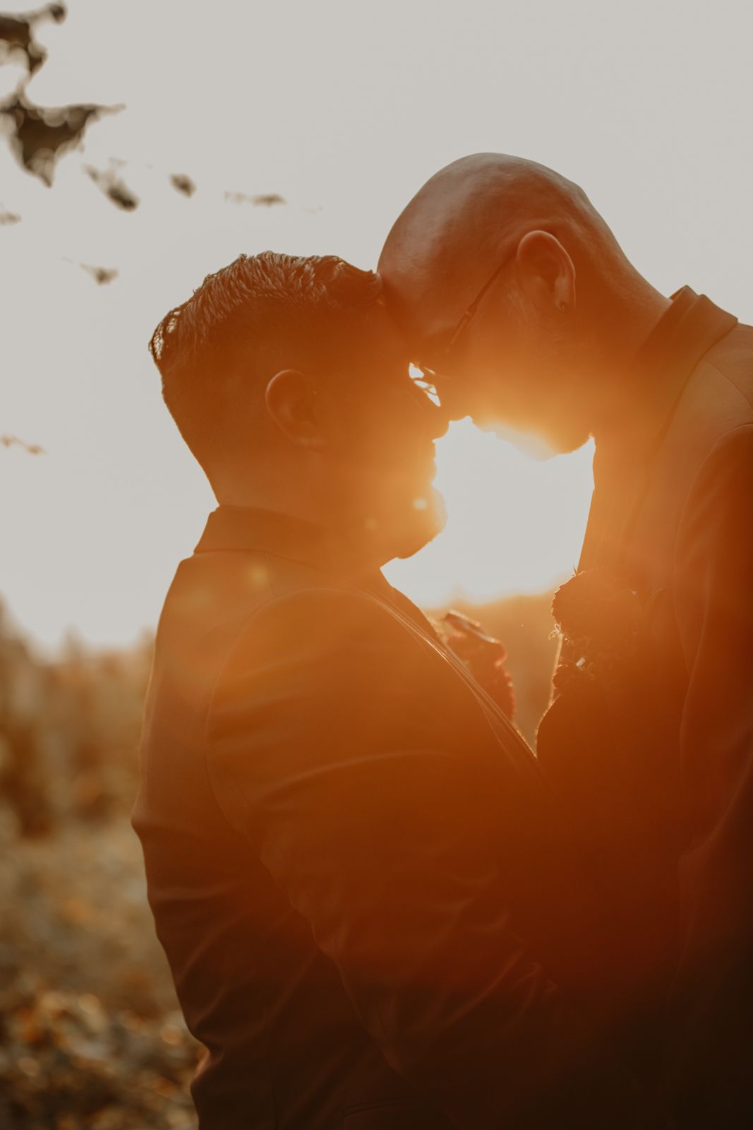 A romantic silhouette of a couple in golden sunlight creating a warm and intimate sunset portrait.