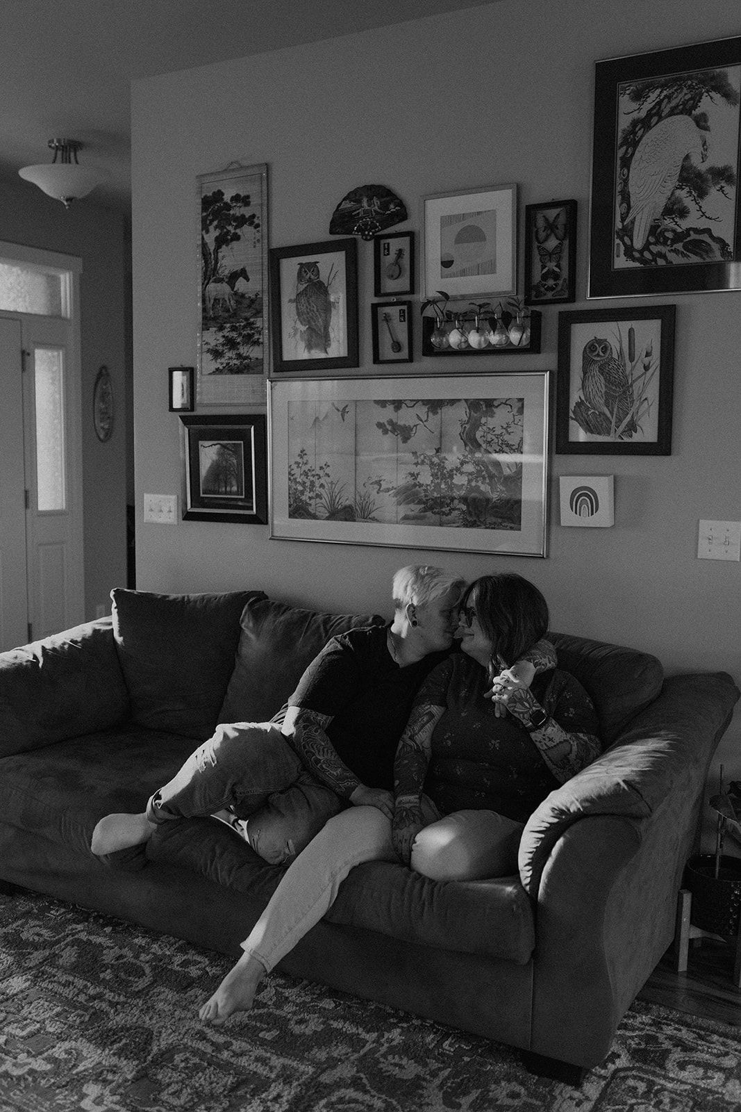 A series of four photos showing someone lounging and reclining on a dark couch in a room decorated with framed artwork.