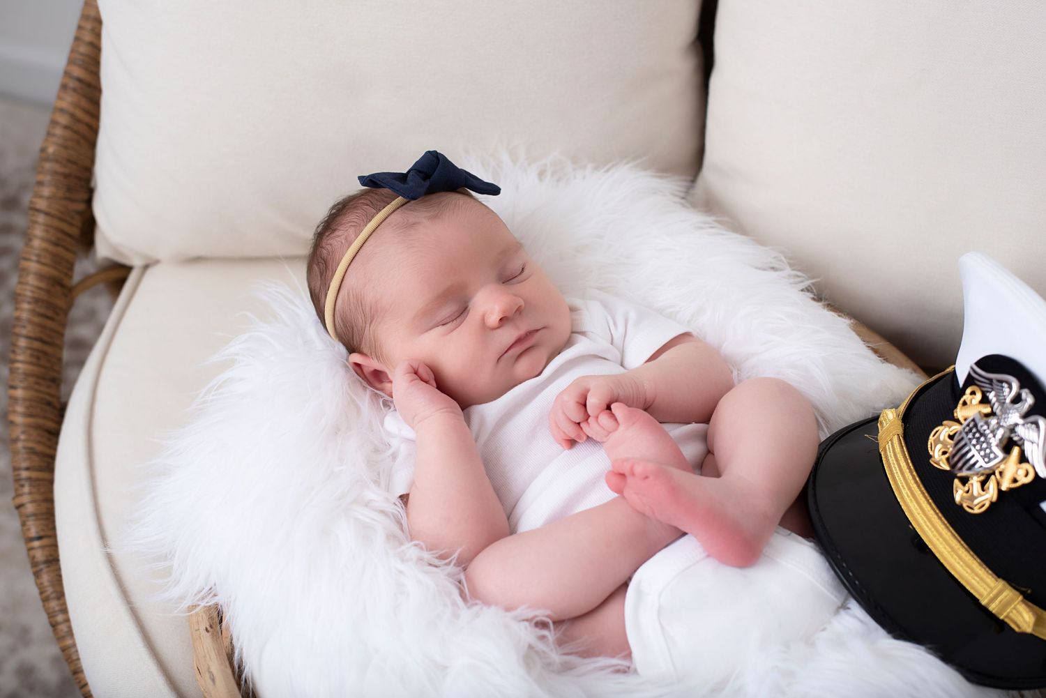 A collage of four photos showing a sleeping baby wearing white clothes laying in a wicker chair.