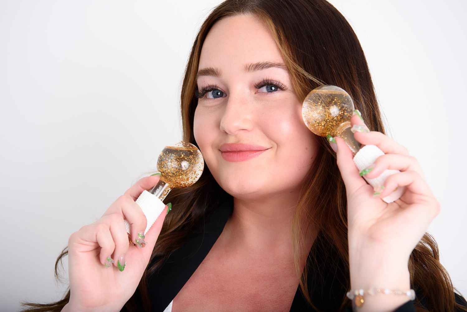 Person holding up a shiny gold bitcoin cryptocurrency coin against a white background.