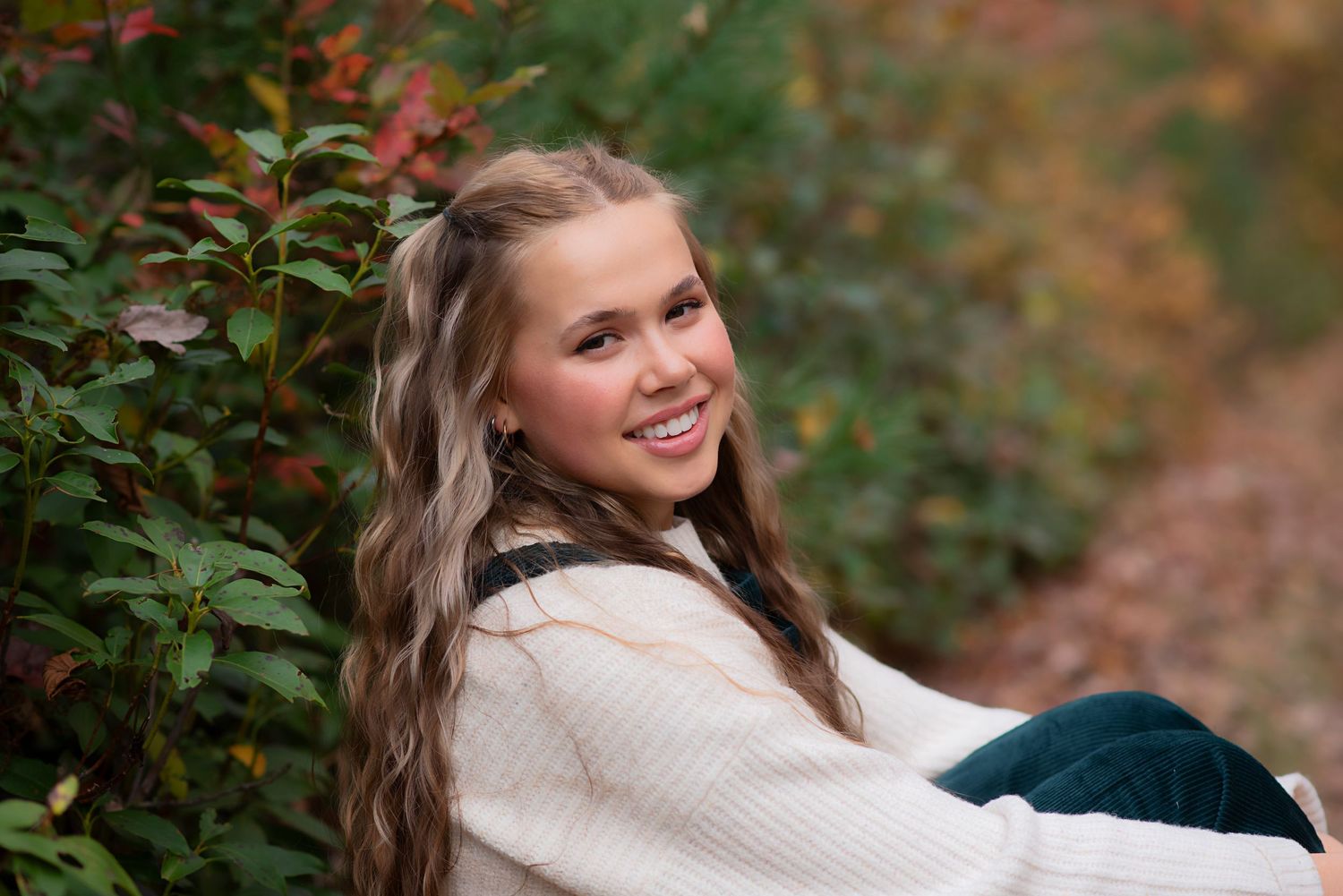 Outdoor portrait against autumn foliage wearing cream sweater in natural lighting. Rhode Island Photographer