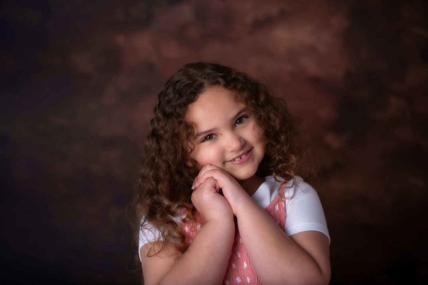 A series of six intimate portraits against a dark brown backdrop showing expressions and poses of joy and emotion.