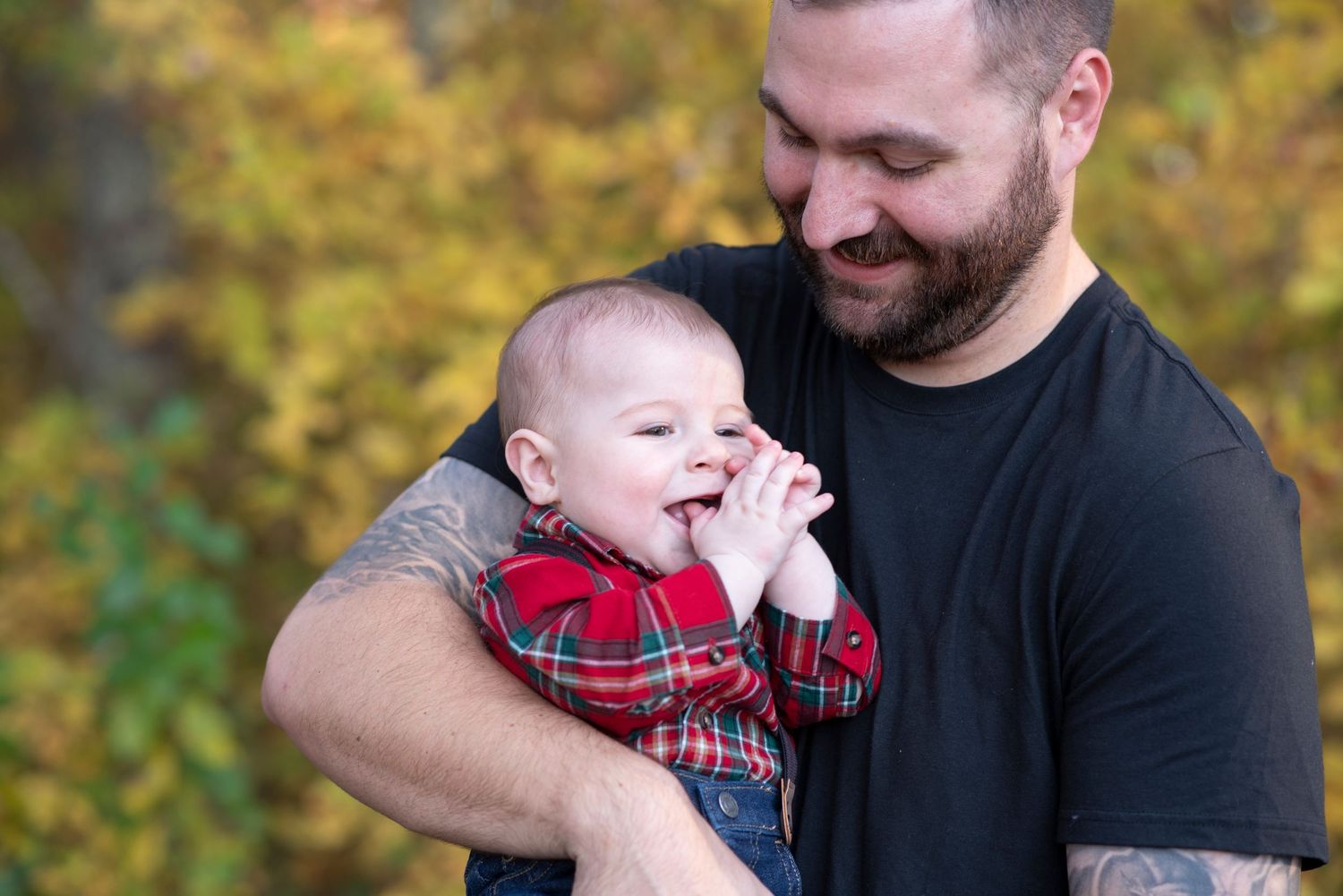 A tender moment between parent and baby captured in a series of candid outdoor autumn photos.