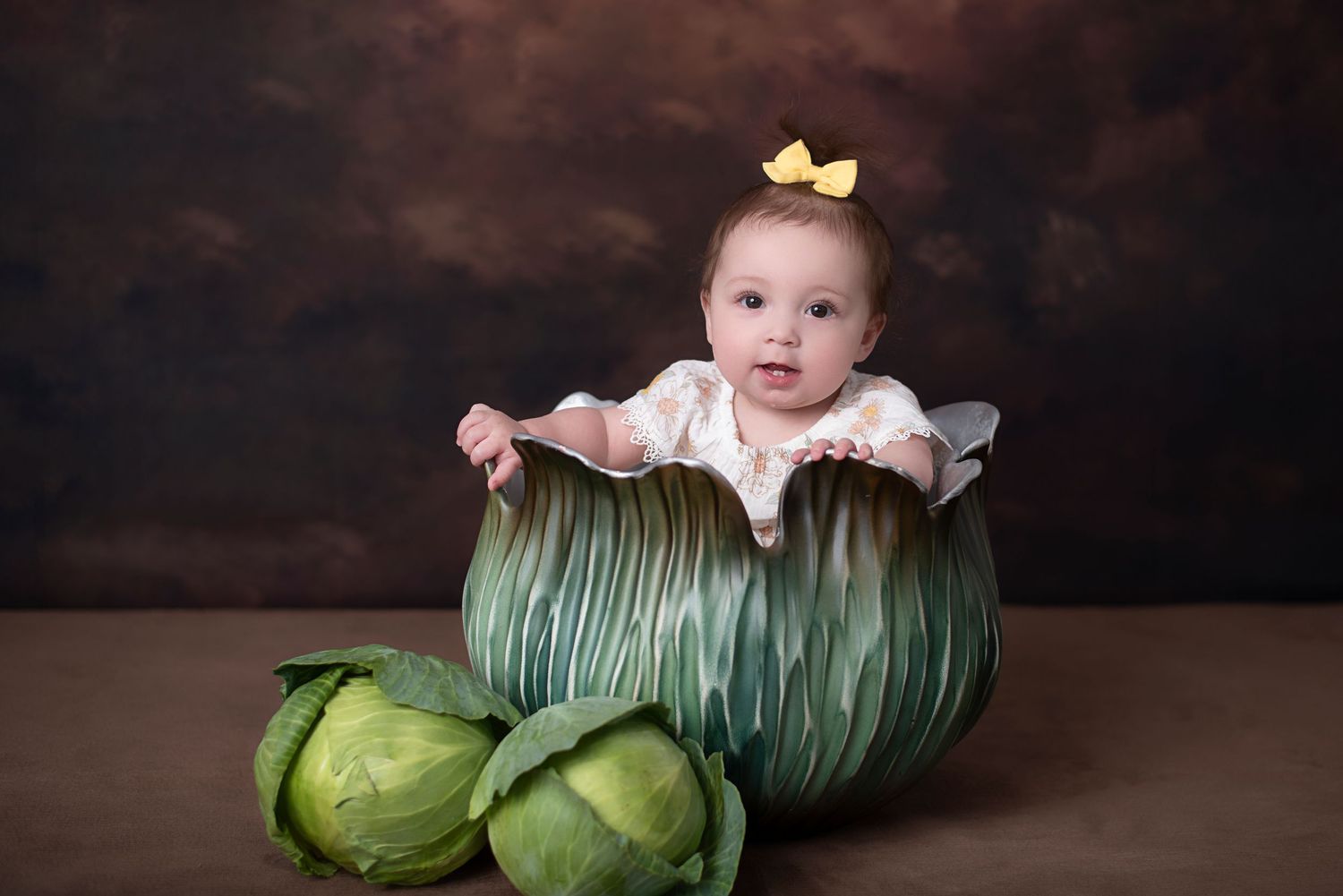 A row of artistically arranged brussels sprouts photographed against a dark, moody background with dramatic lighting.