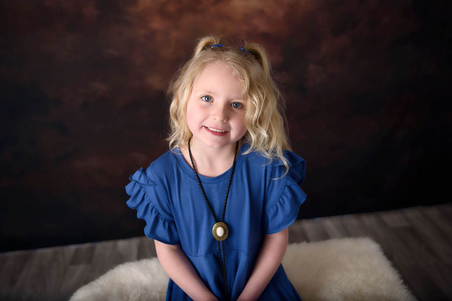 A series of seven photographs showing someone in a vibrant blue dress against a dark dramatic backdrop.