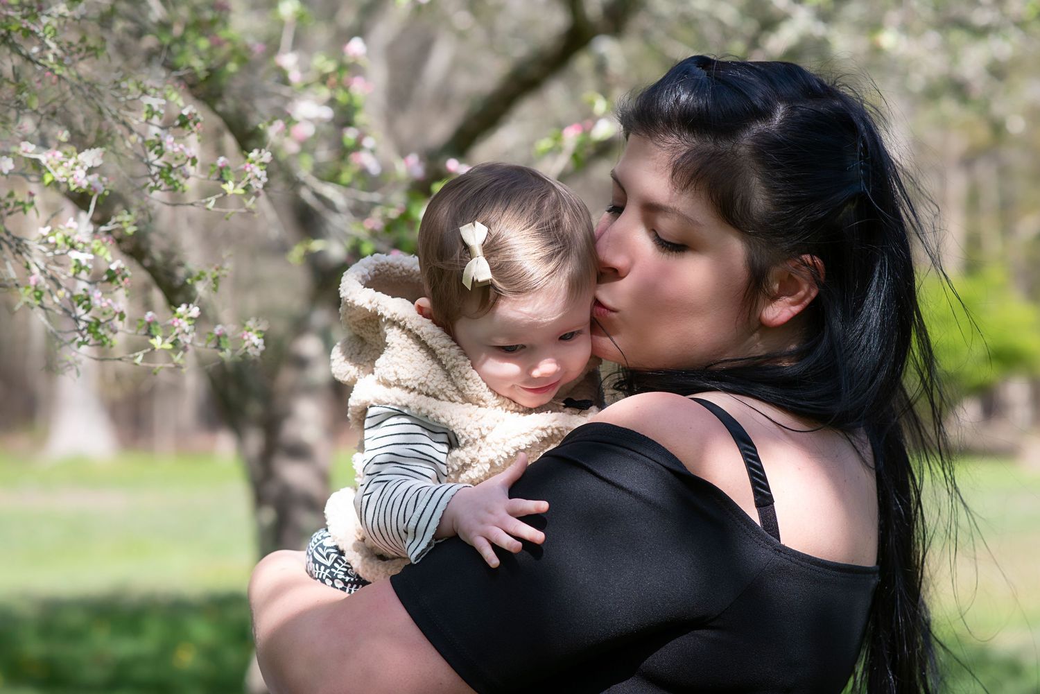 A series of seven intimate moments shared between a couple in an outdoor spring setting with blossoming trees.