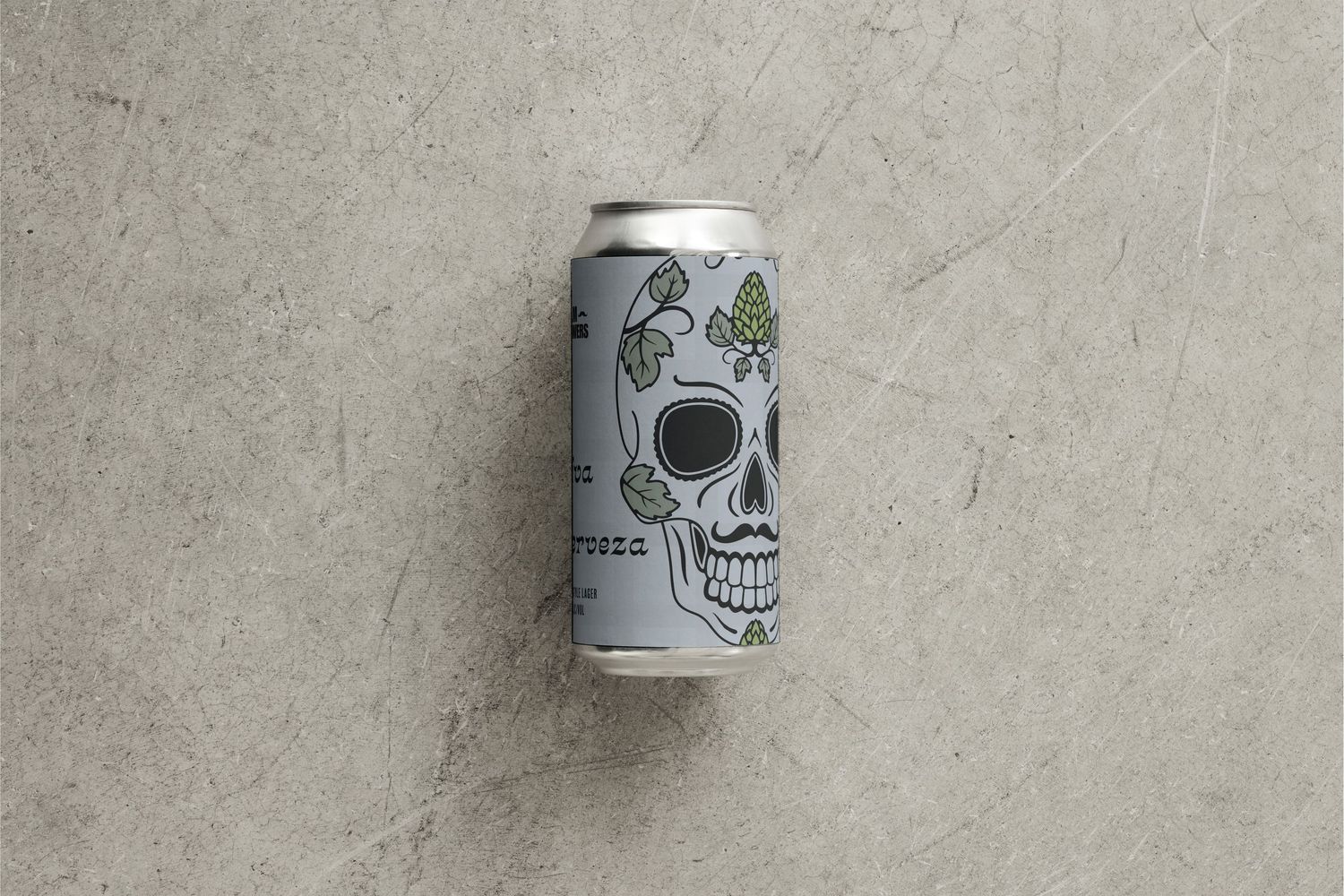 Image of a beer can with a hop-inspired sugar skull illustration on a grey flannel background.