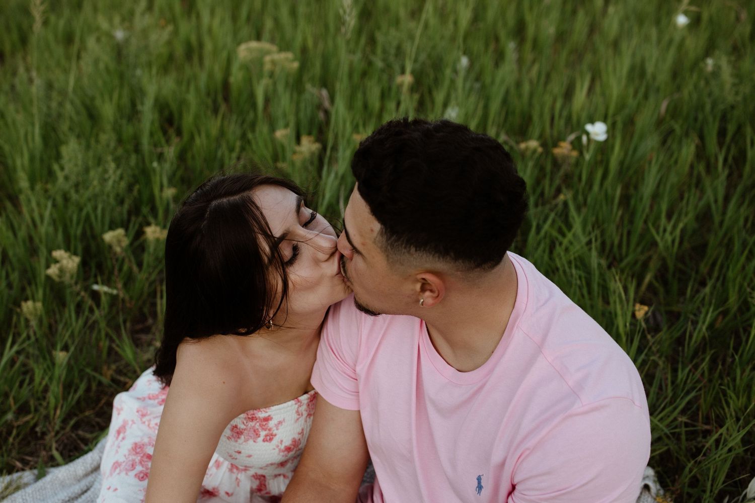 Couple sharing tender moments together in a sun-drenched wildflower field.