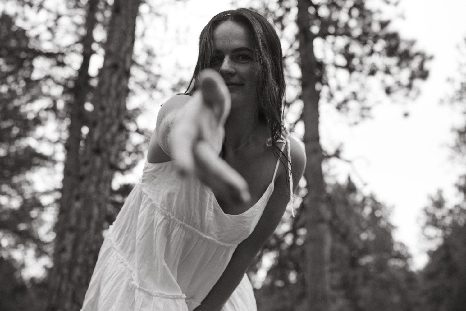 An artistic black and white portrait captured in a forest setting.