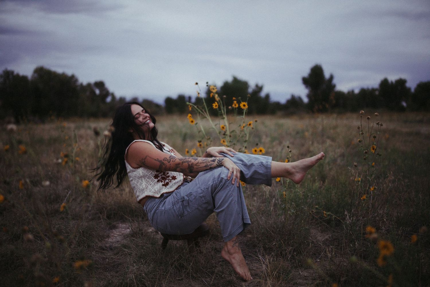 A dreamy outdoor photoshoot in a field with wildflowers at sunset.