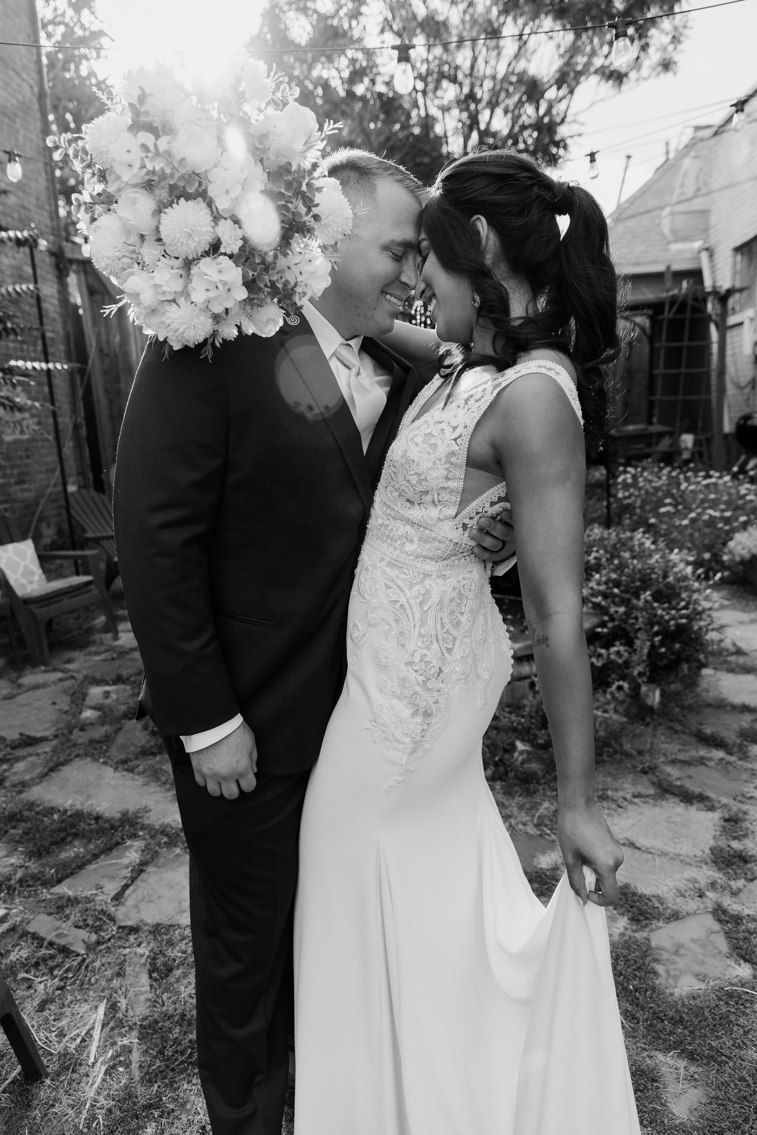 Black and white portrait of newlyweds with elegant floral arrangements.