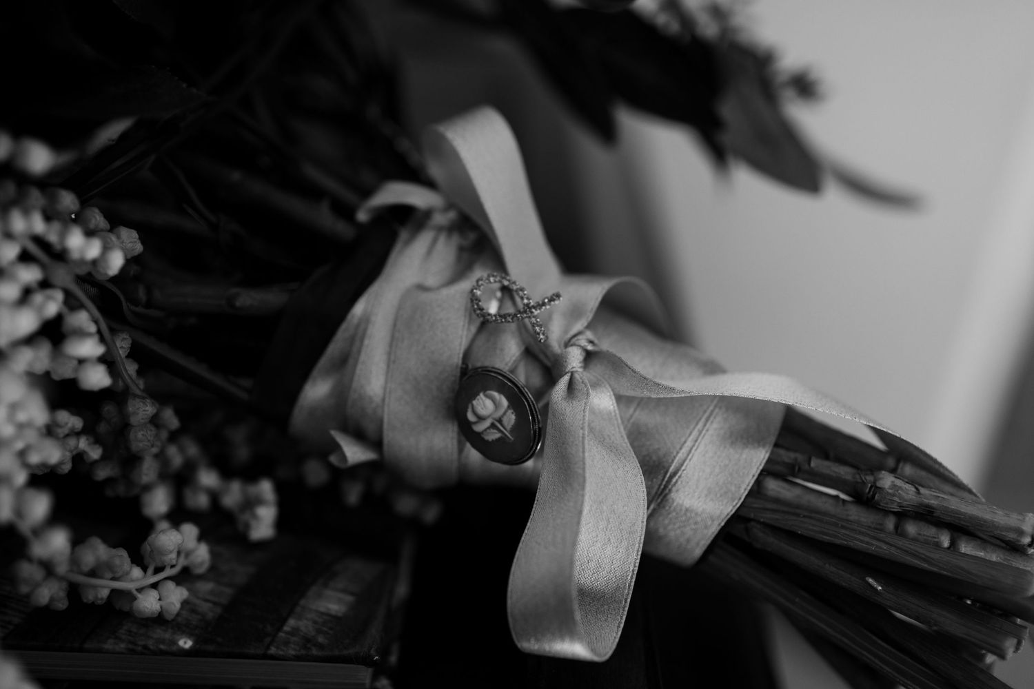 A romantic black and white wedding portrait of a couple sharing an intimate moment outdoors.