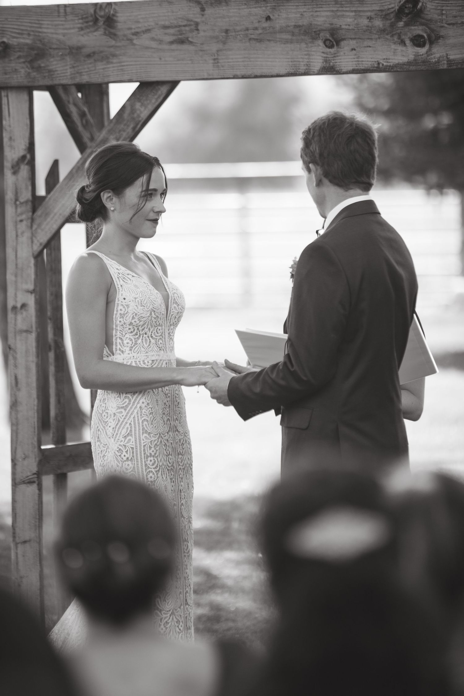 Black and white ceremony photos showing couple exchanging vows under wooden beams.