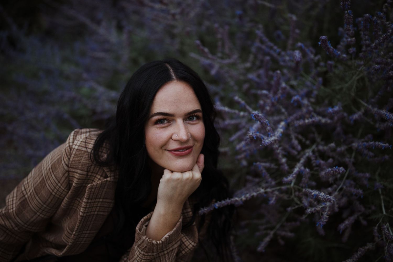 A romantic outdoor photoshoot in a field of purple lavender flowers at sunset.