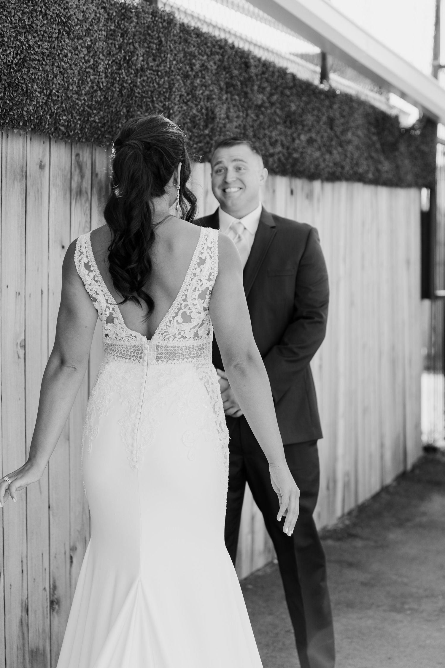 Candid wedding photos showing couple walking along rustic wooden fence.