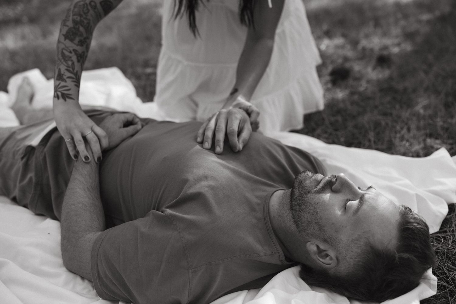 Black and white portrait session showing relaxed poses on a blanket outdoors.