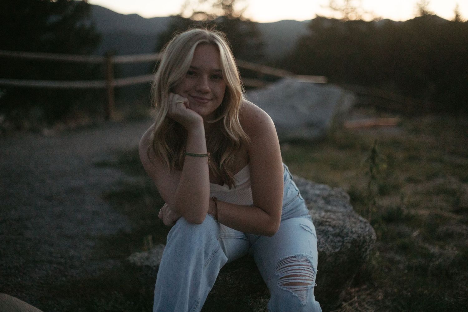 Outdoor portrait session at sunset with mountain scenery in the background.