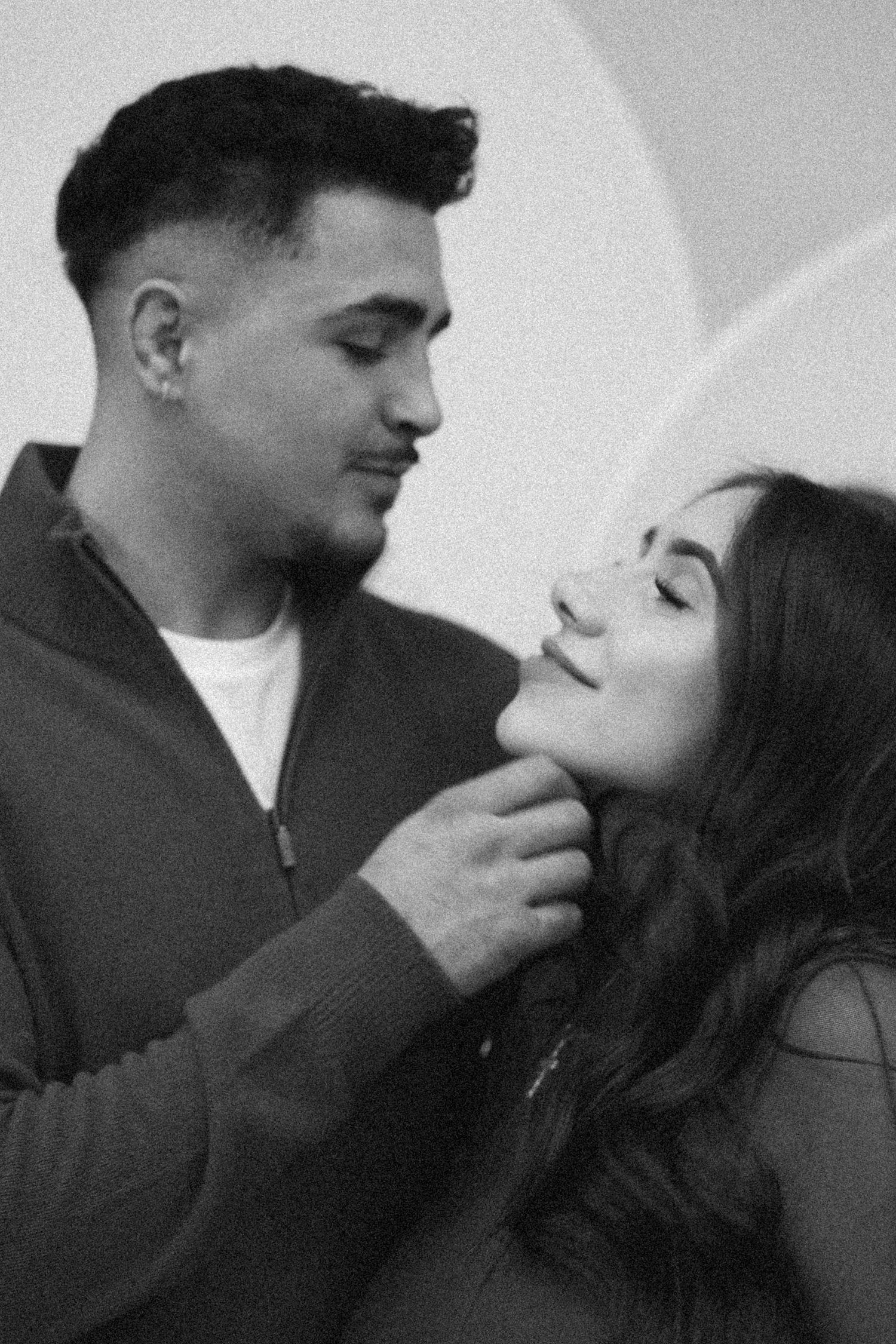 A romantic black and white portrait of a couple sharing an intimate moment.