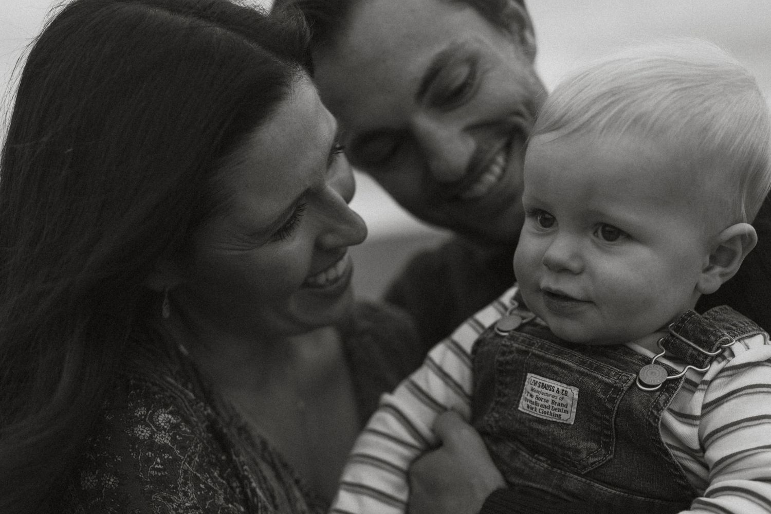A series of black and white photographs showing tender moments between a parent and child.