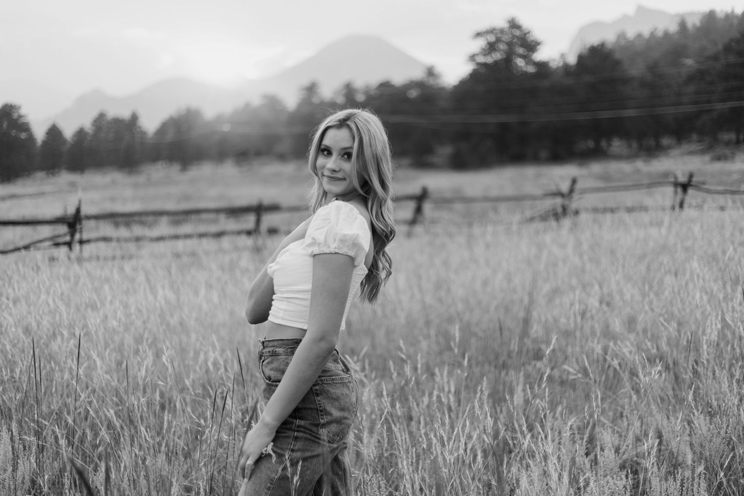 Black and white portraits in a rustic field with mountains visible in the distance.