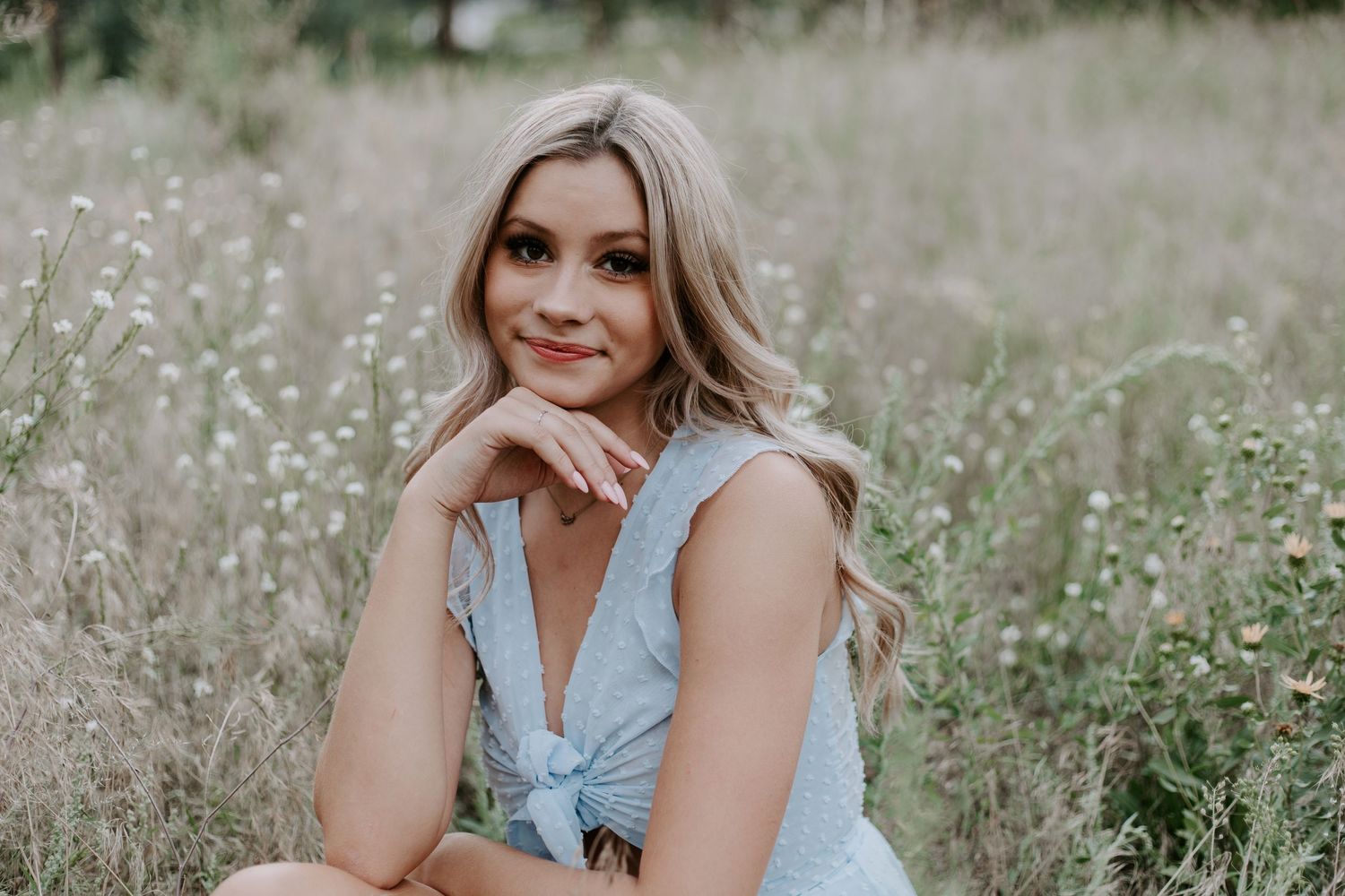 Summer portrait session in a wildflower meadow with soft natural lighting.